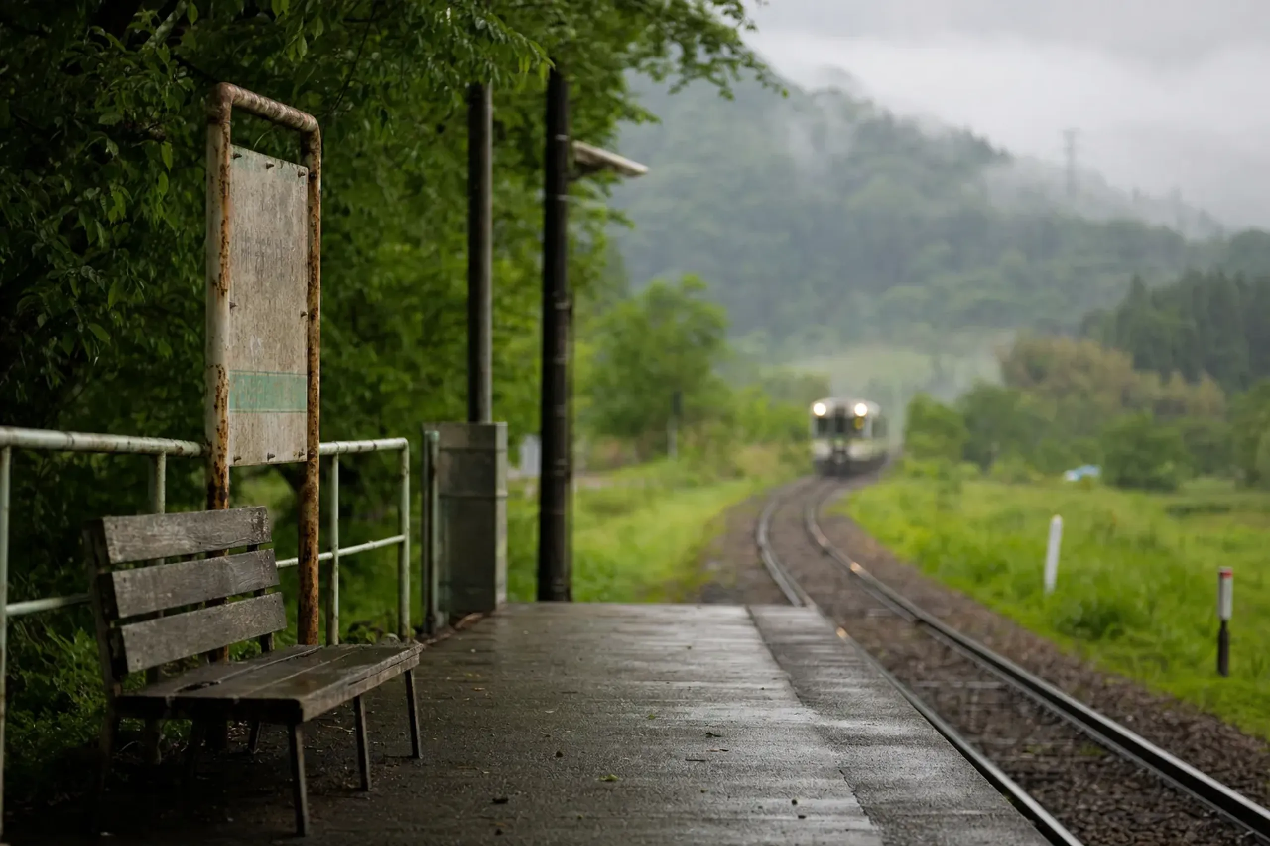 a single-track rural platform of the JR Ban'etsu West Line local train winding through the inland Fukushima countryside toward Aizu-Wakamatsu