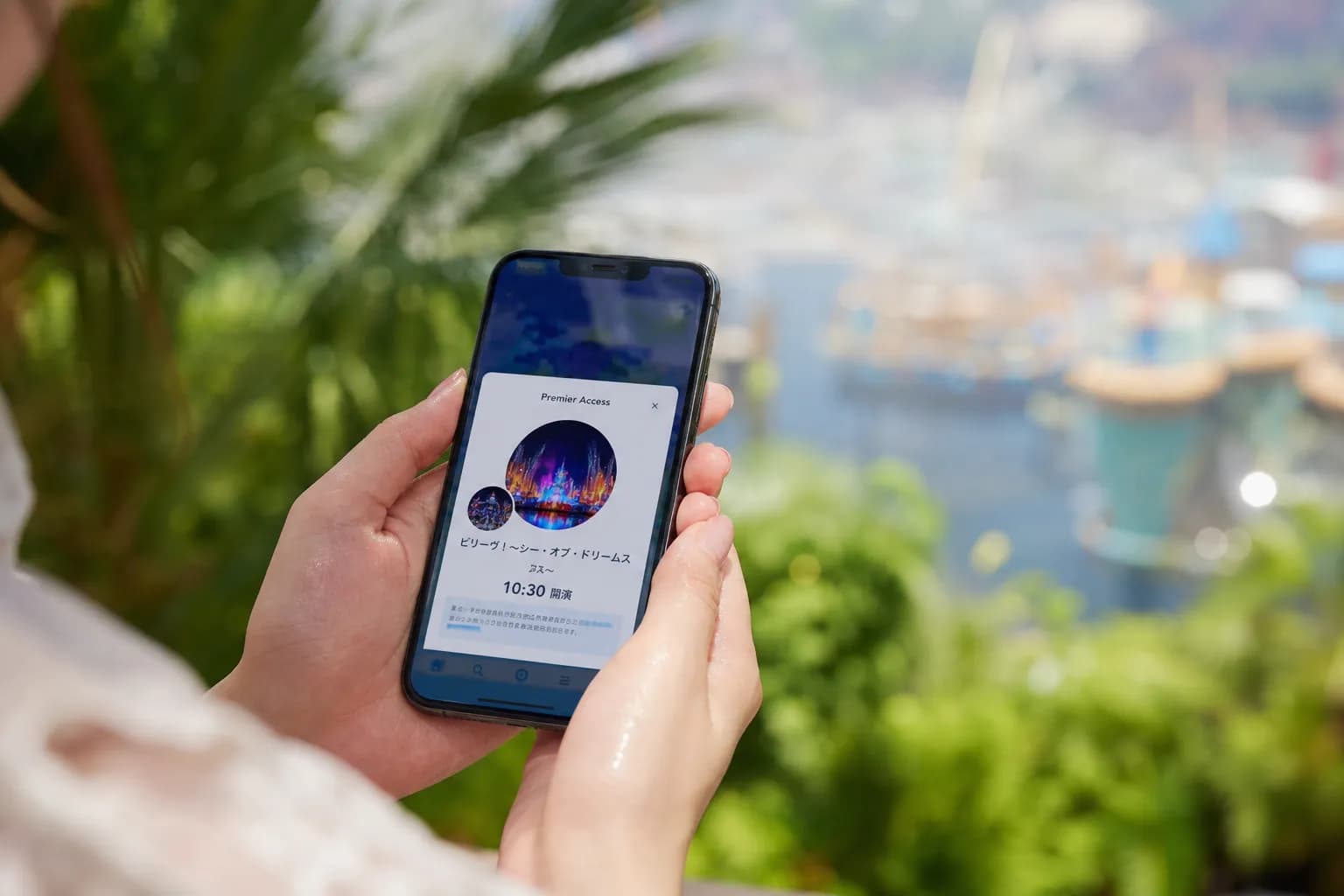Person using a smartphone app inside a theme park to buy a ride time