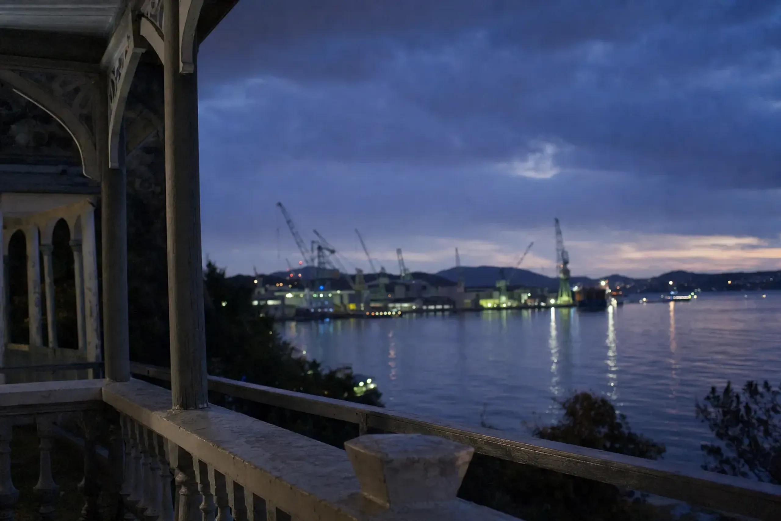 Nagasaki harbor and the shipyard cranes across the water during blue hour, viewed from the terrace of the Former Glover House