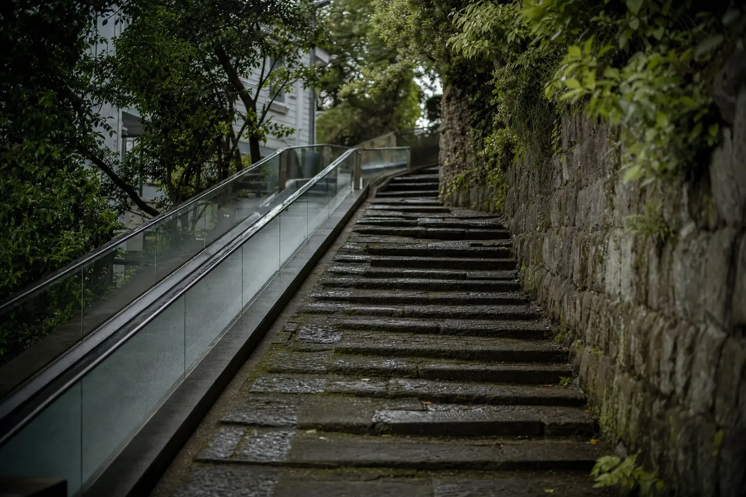 The sloping stone steps and moving walkways winding up the steep hillside of Glover Garden in Minami-Yamate