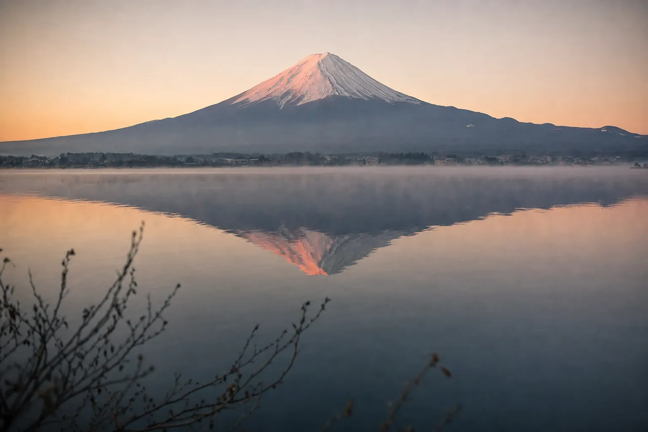 Mount Fuji reflected across the still surface of Lake Kawaguchiko on a clear winter morning
