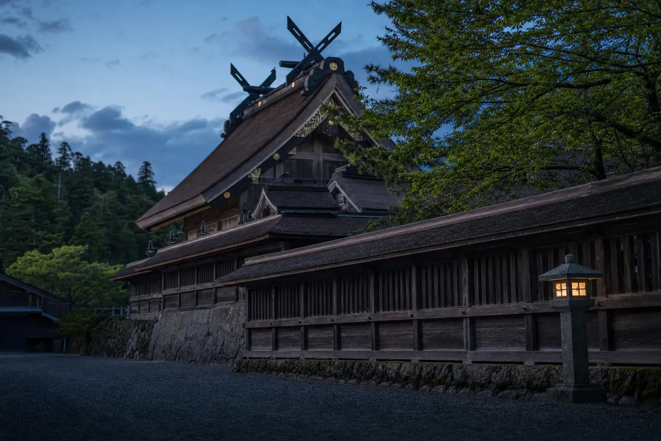 The main sanctuary of Izumo Taisha enshrining Okuninushi no Okami, seen behind its wooden fence at dusk