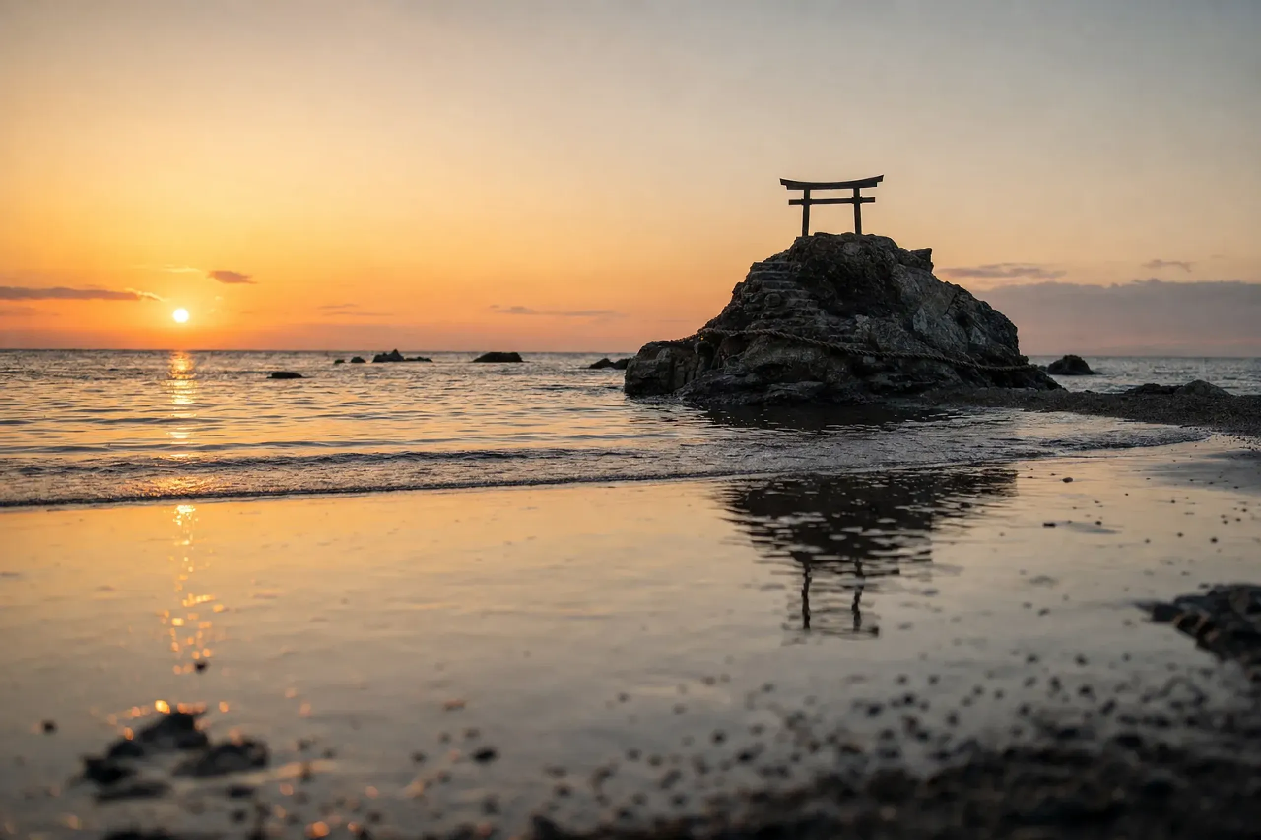 Inasa Beach west of Izumo Taisha at sunset, with its small torii on the offshore rock where the deities are welcomed from the sea