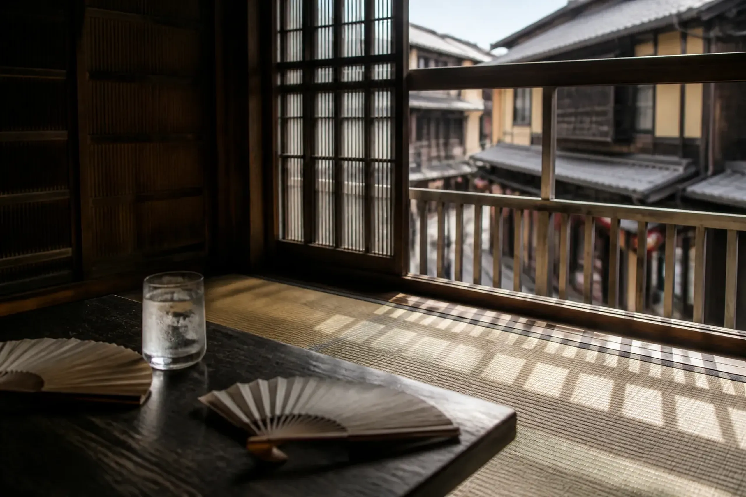 Traditional tatami room with an open lattice window overlooking a Japanese festival street below