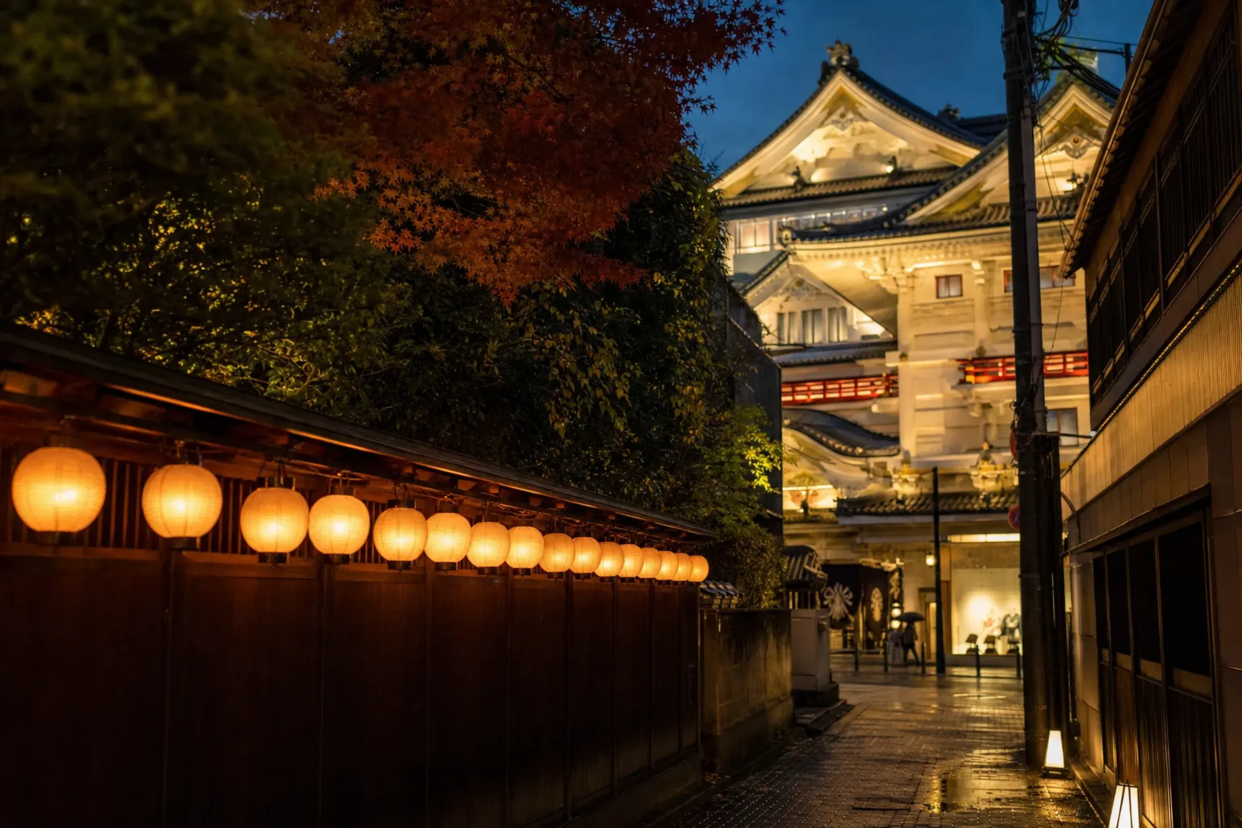 A narrow lantern-lit Ginza side street near Higashi-Ginza Station with the Kabukiza rooftop visible above
