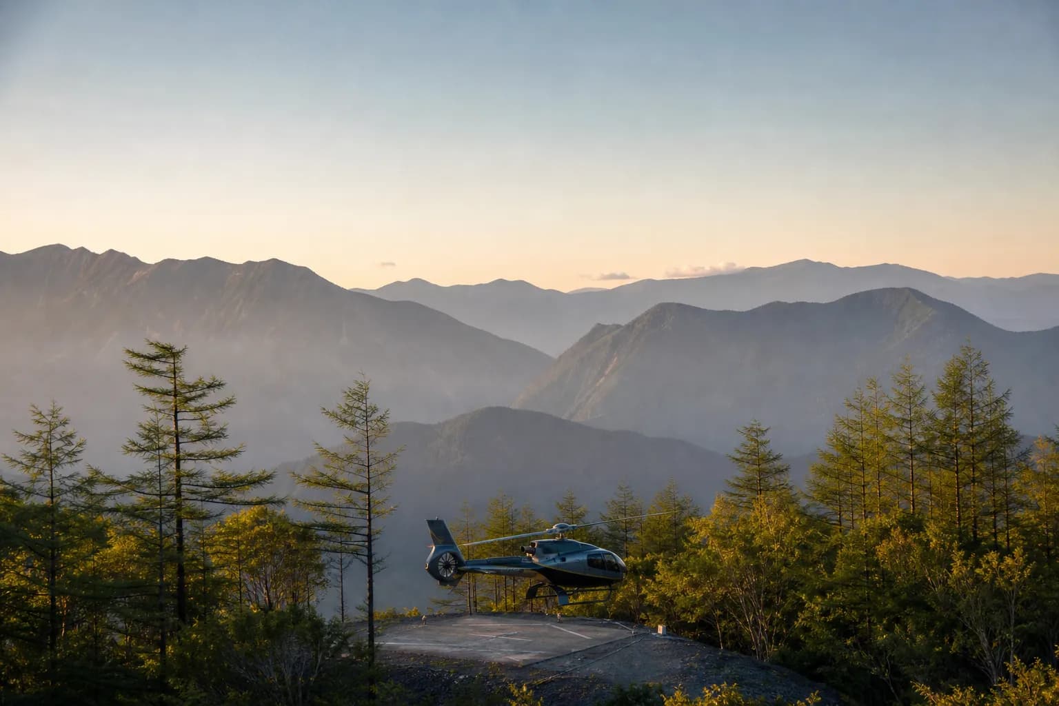 A private helicopter descending toward an alpine landing zone amid the Japanese larch forests of Karuizawa, with the misty Nagano highland ridgelines in the background