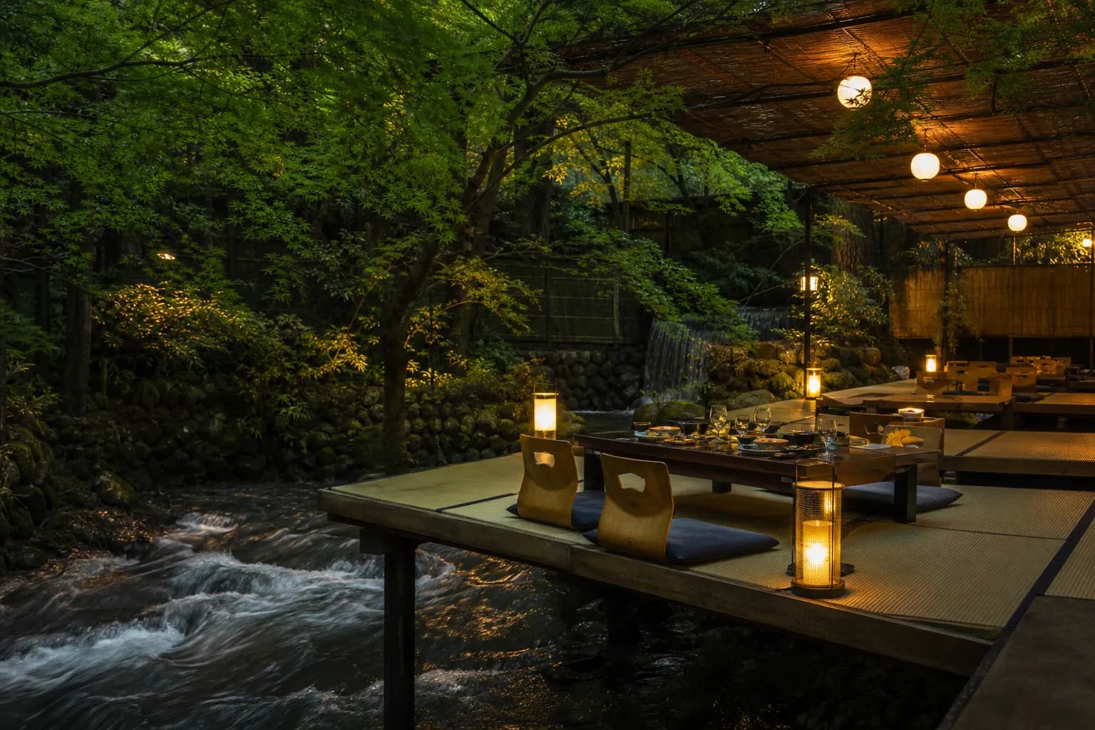 Wooden kawadoko dining platform over the Kibune River surrounded by green maples in summer