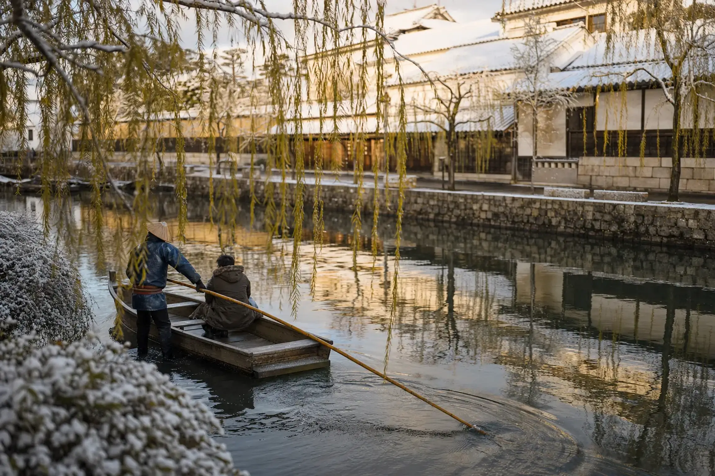 a traditional wooden kawabune boat gliding beneath willow branches on the still Kurashiki River