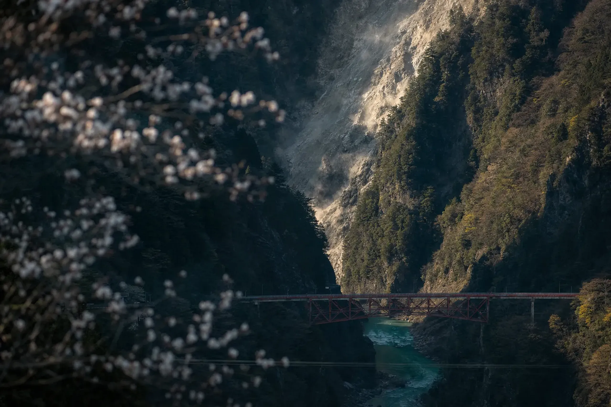 The Kanetsuri Bridge spanning the Kurobe Gorge, with fresh rockfall scarring the steep slope of Higashi-Kanetsuri-yama above it