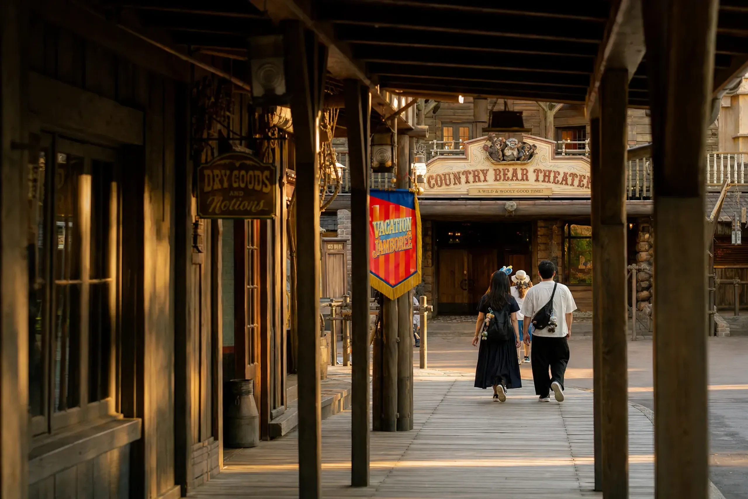the shaded wooden walkways and frontier storefronts of Westernland at Tokyo Disneyland leading toward the Country Bear Theater entrance