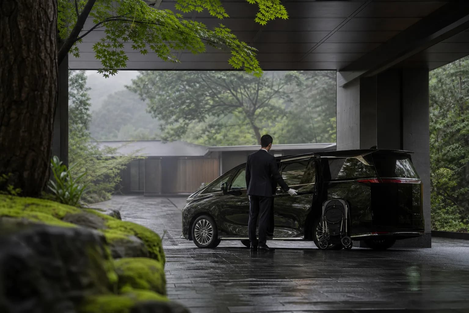 Chauffeur opening the door of a Lexus LM 500 luxury van for a family transfer