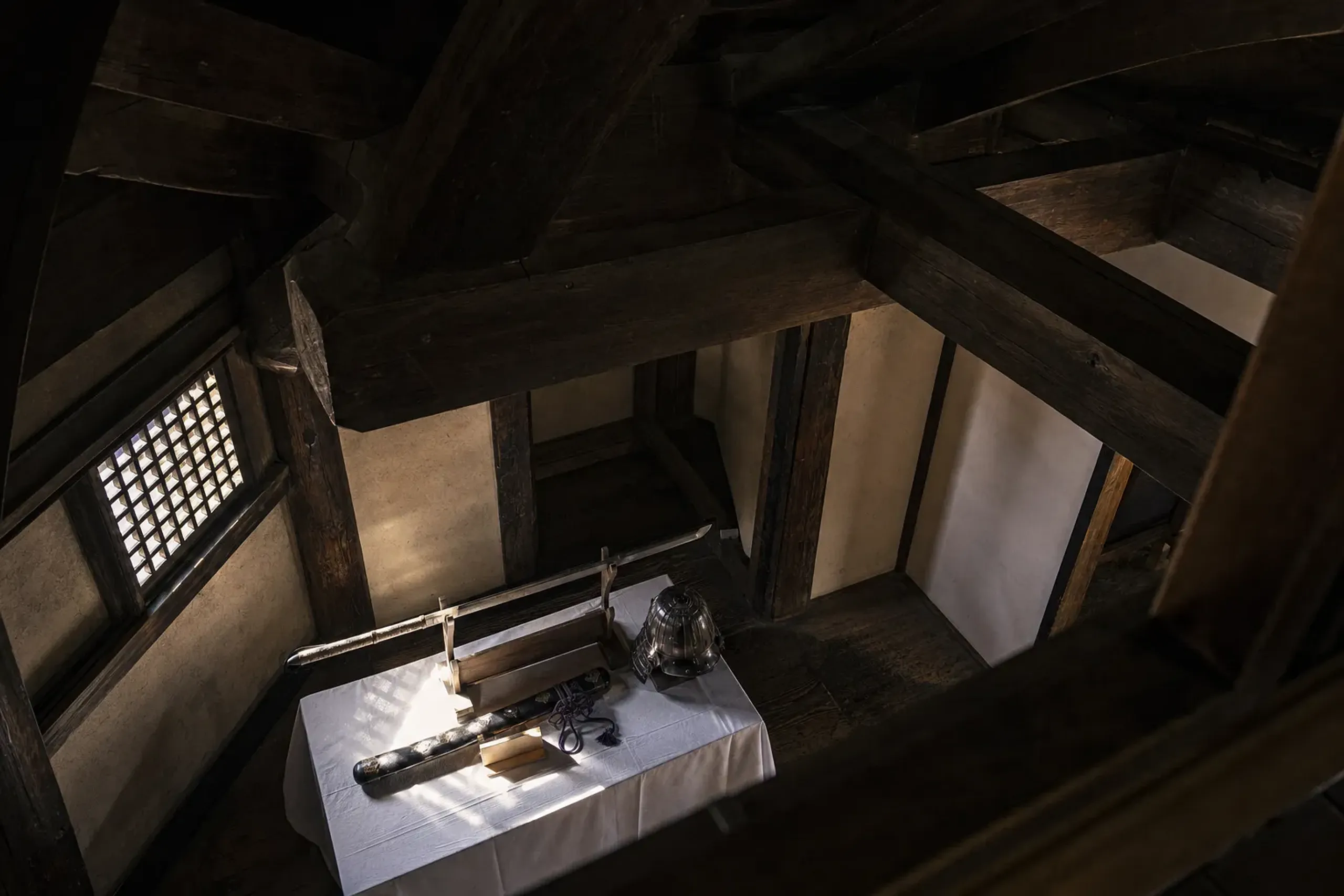 Interior exhibits inside Matsuyama Castle keep displaying Edo-period weaponry and traditional timber joinery of the tower's wooden beams
