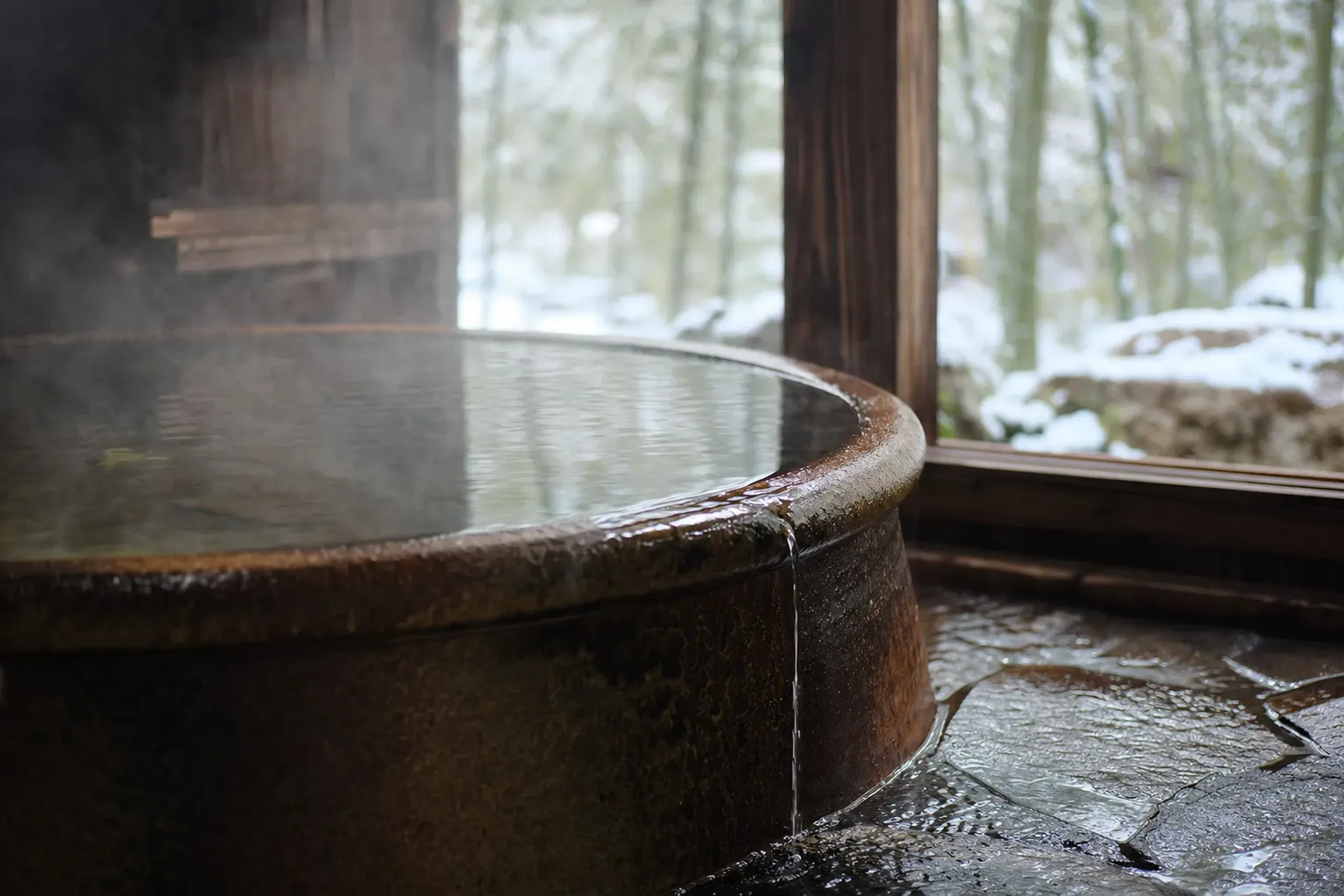 The Shigaraki-ware ceramic bath at Mori no Yu, a large glazed earthenware tub brimming with steaming spring water