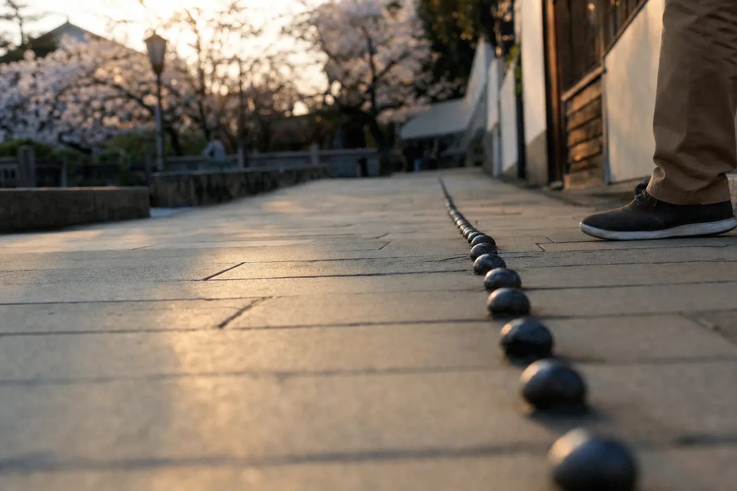 the iron rivets set into the road along Dejima's south side marking the 1867 seawall line, tracing the old waterline underfoot