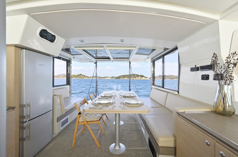 The air-conditioned salon of the catamaran TAMANO, laid for lunch, with the Seto Inland Sea through the windows
