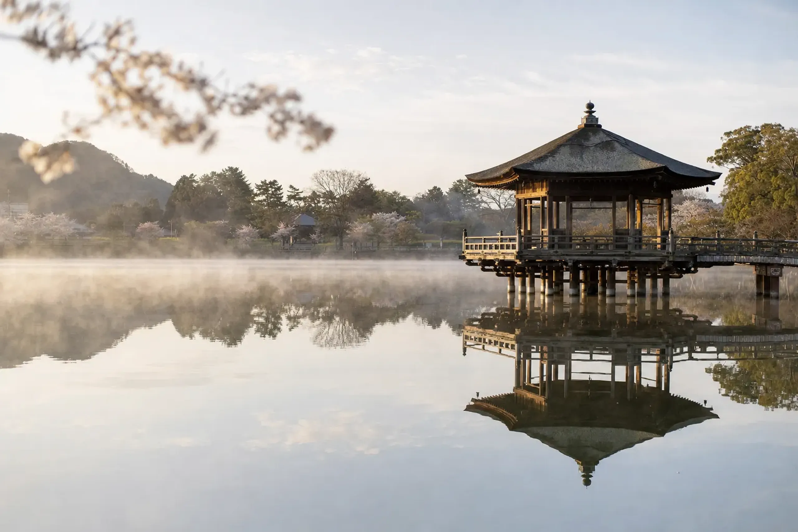 the Ukimidō pavilion appearing to float on the still water of Sagiike Pond in Nara Park at early morning