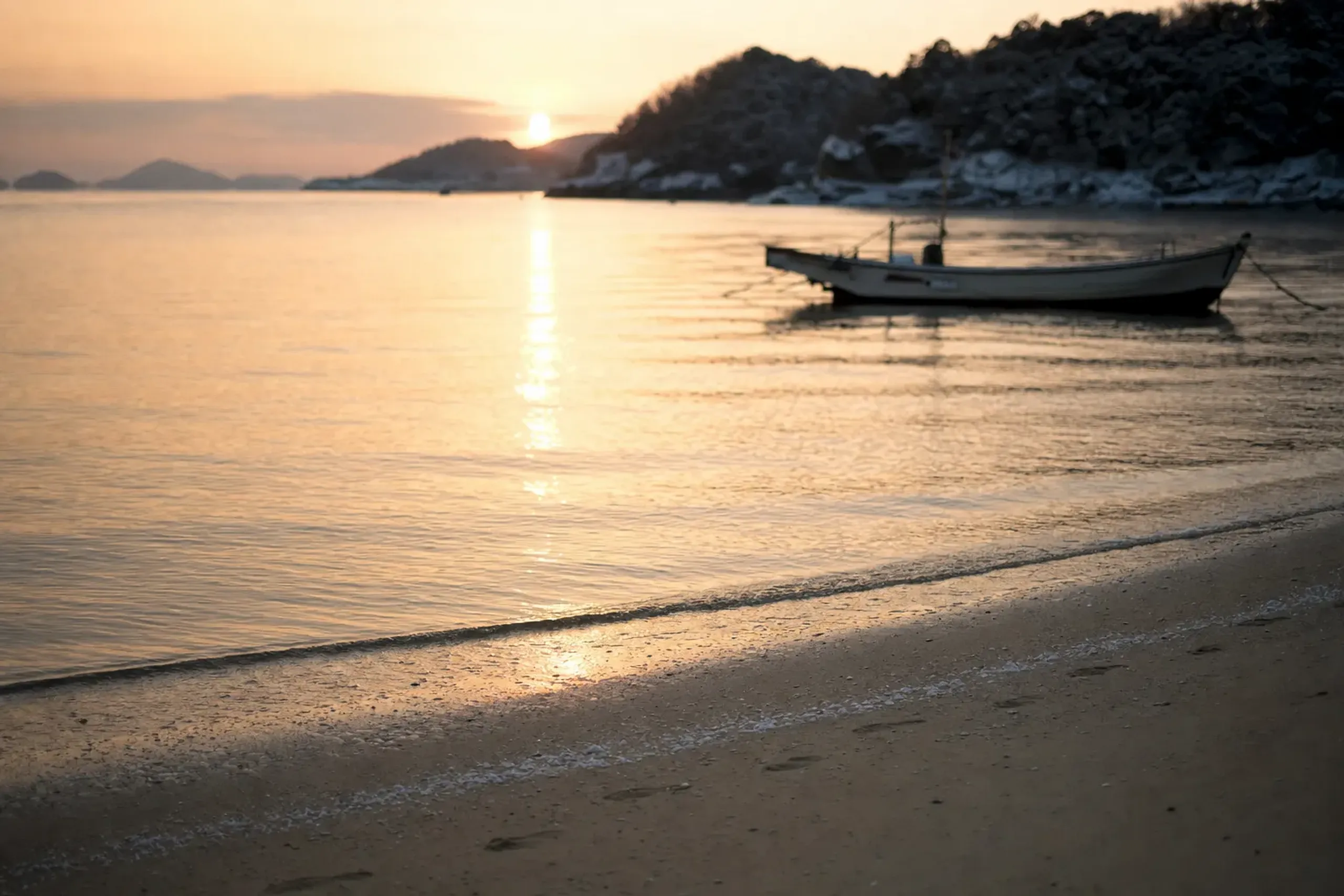 Okinawa shoreline in autumn with warm sunset light and a small boat on calm water