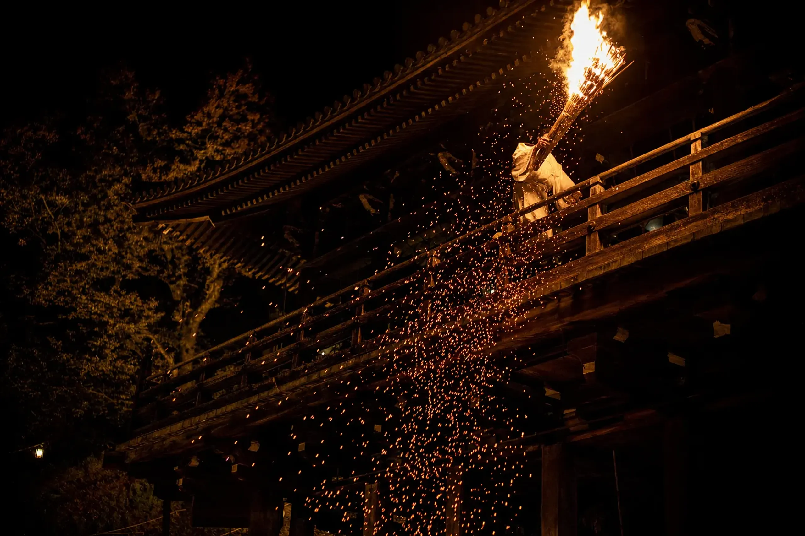 Otaimatsu torch ceremony at Nigatsudo with a torch-bearer on the balcony and sparks falling