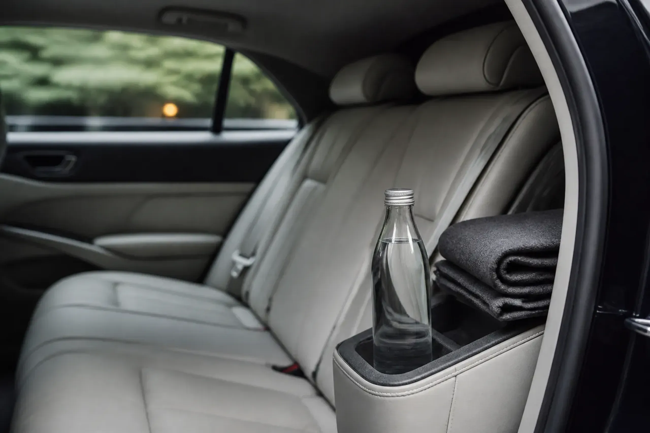Luxury vehicle interior with clean leather seats and discreet amenities, no people