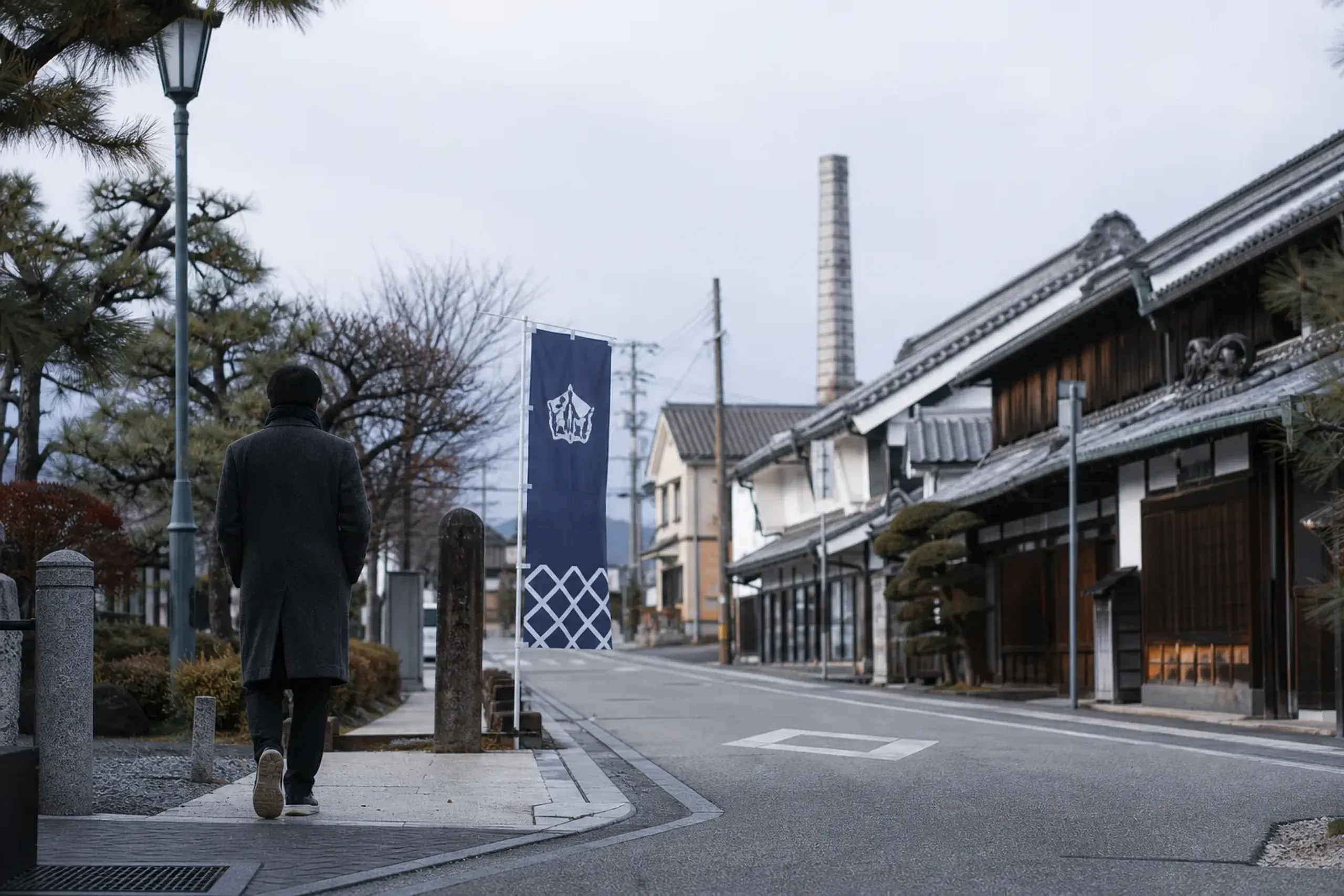Visitor walking from JR Saijō Station area toward Saijō sake brewery street in Higashihiroshima