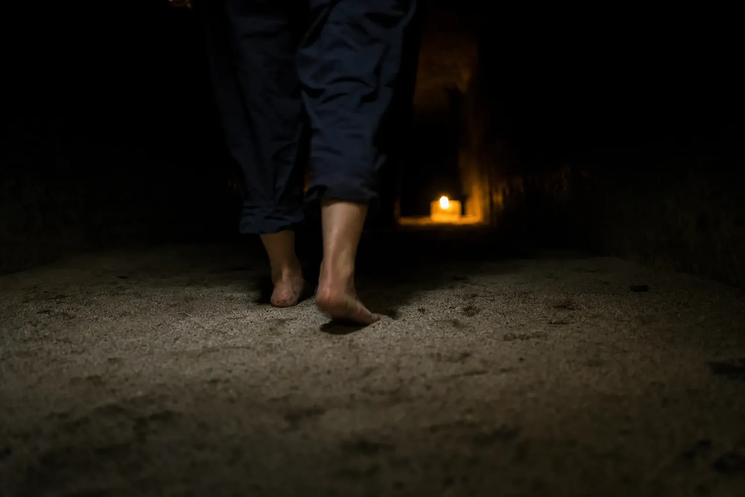 the dim sand-treading corridor inside the reclining Buddha, where visitors walk barefoot over sand from the 88 Shikoku temples