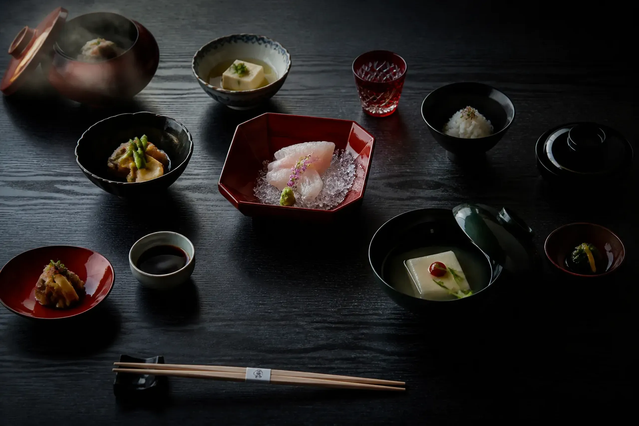 Multi-course kaiseki dinner on lacquer dishes at a traditional ryokan, included in per-person pricing