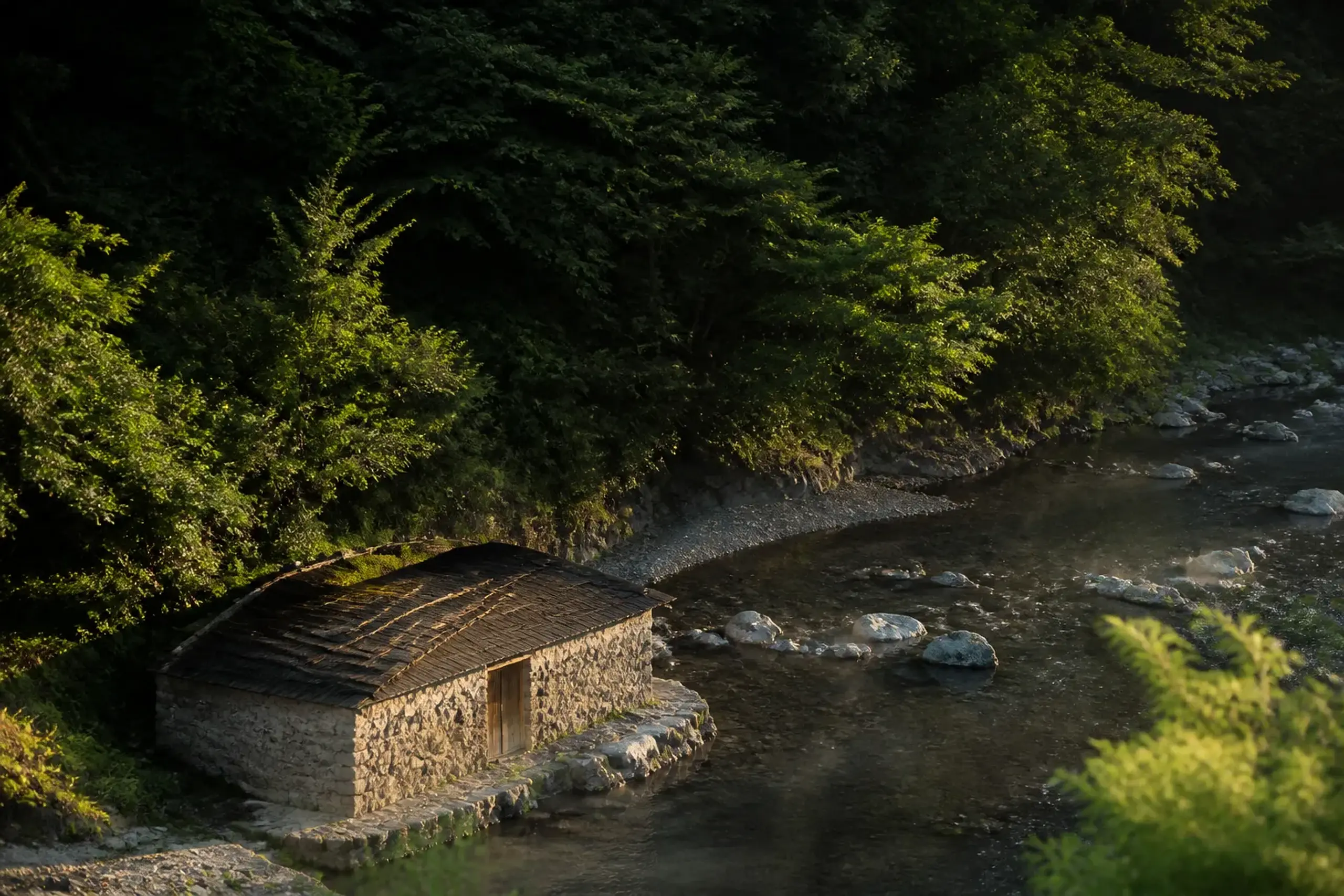 Stone onsen bathhouse beside a stream at Yunomine Onsen in the Kumano Kodo region