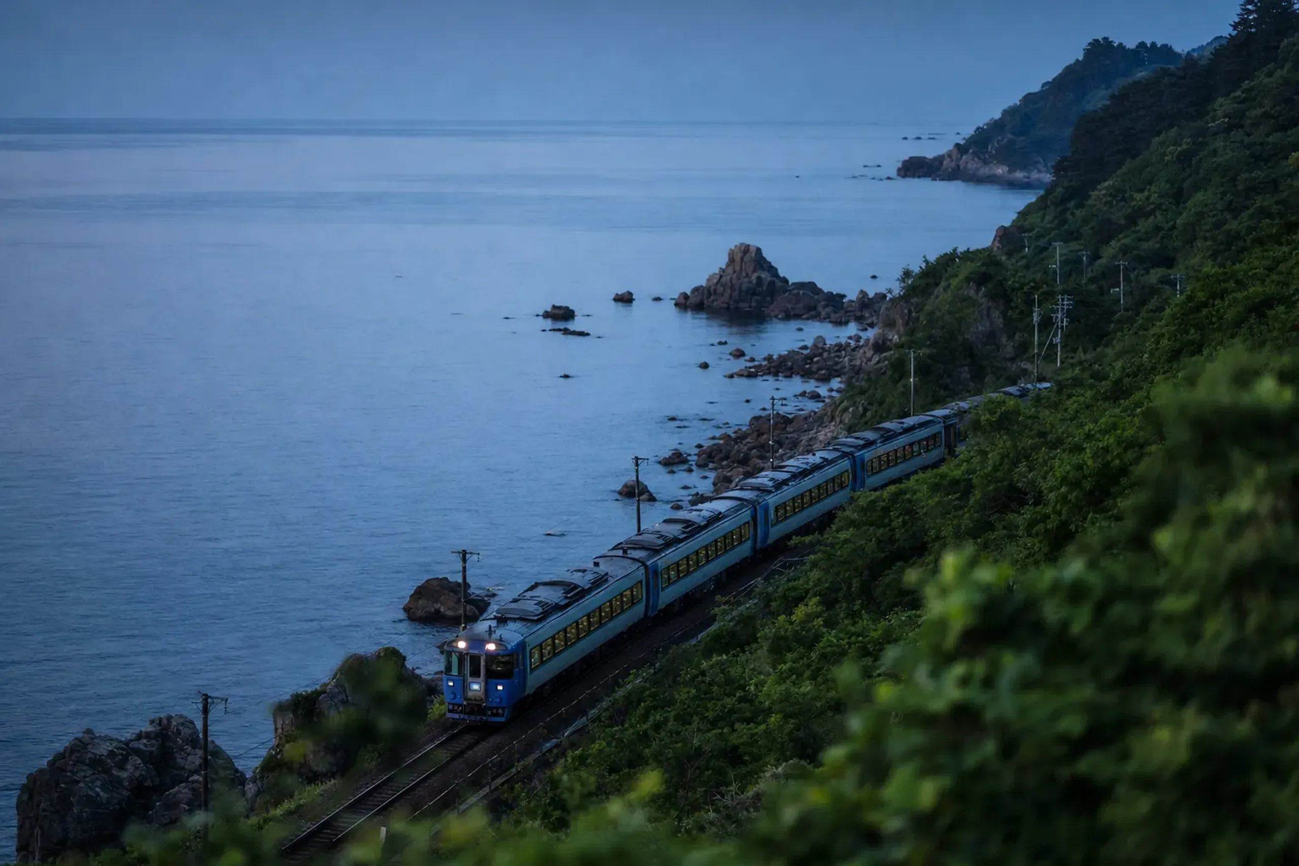 The Resort Shirakami sightseeing train of JR East running along the coastline rails beside the Sea of Japan