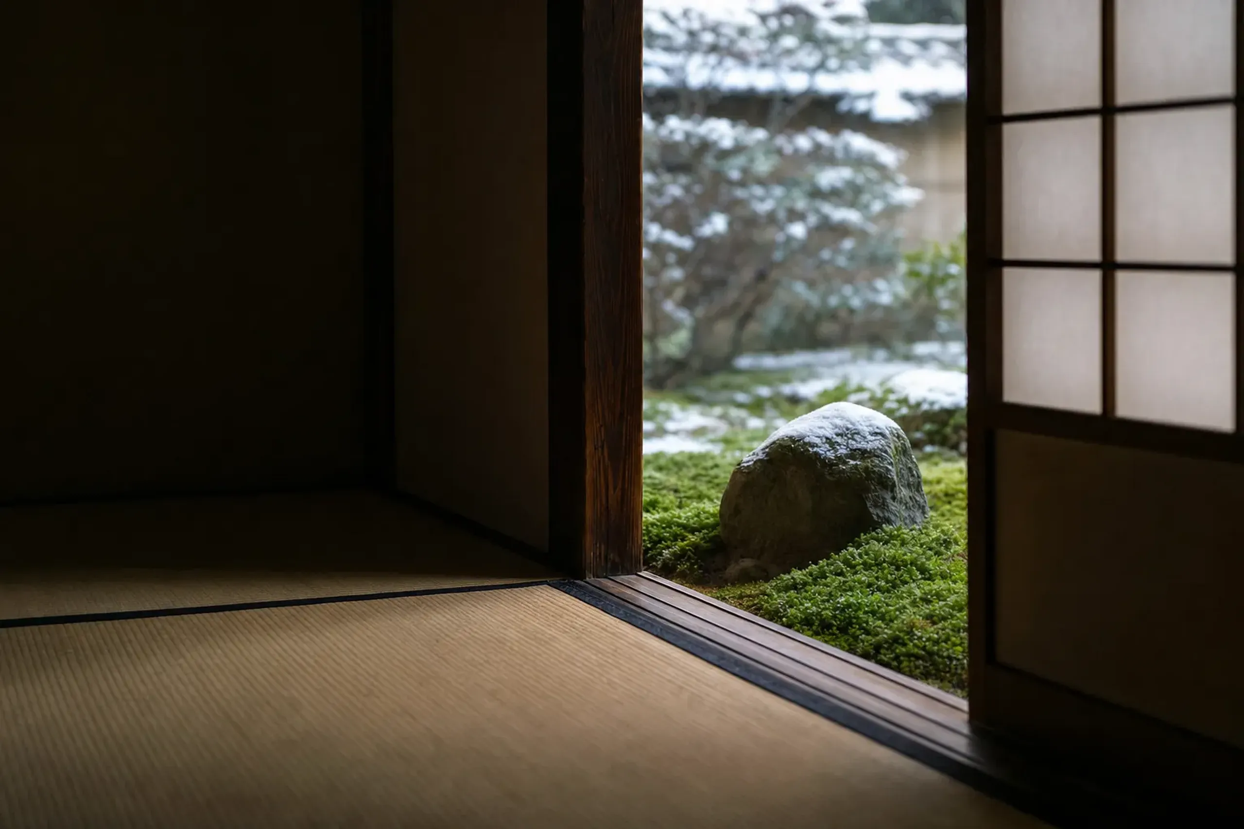 a room-to-room garden view at Sumiya framing close-up moss and stone through an open shoji screen
