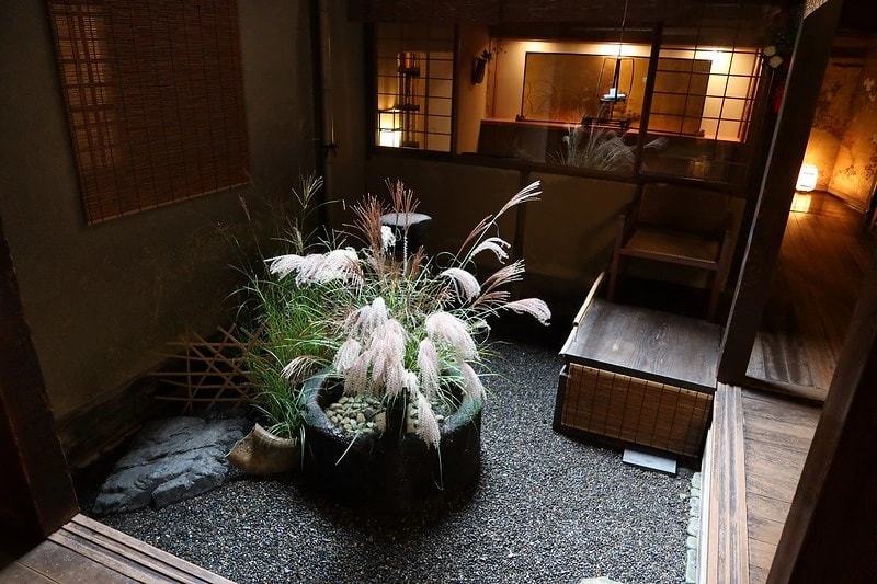 Ryokan interior still life with soft lighting, bedding detail, and simple flower arrangement