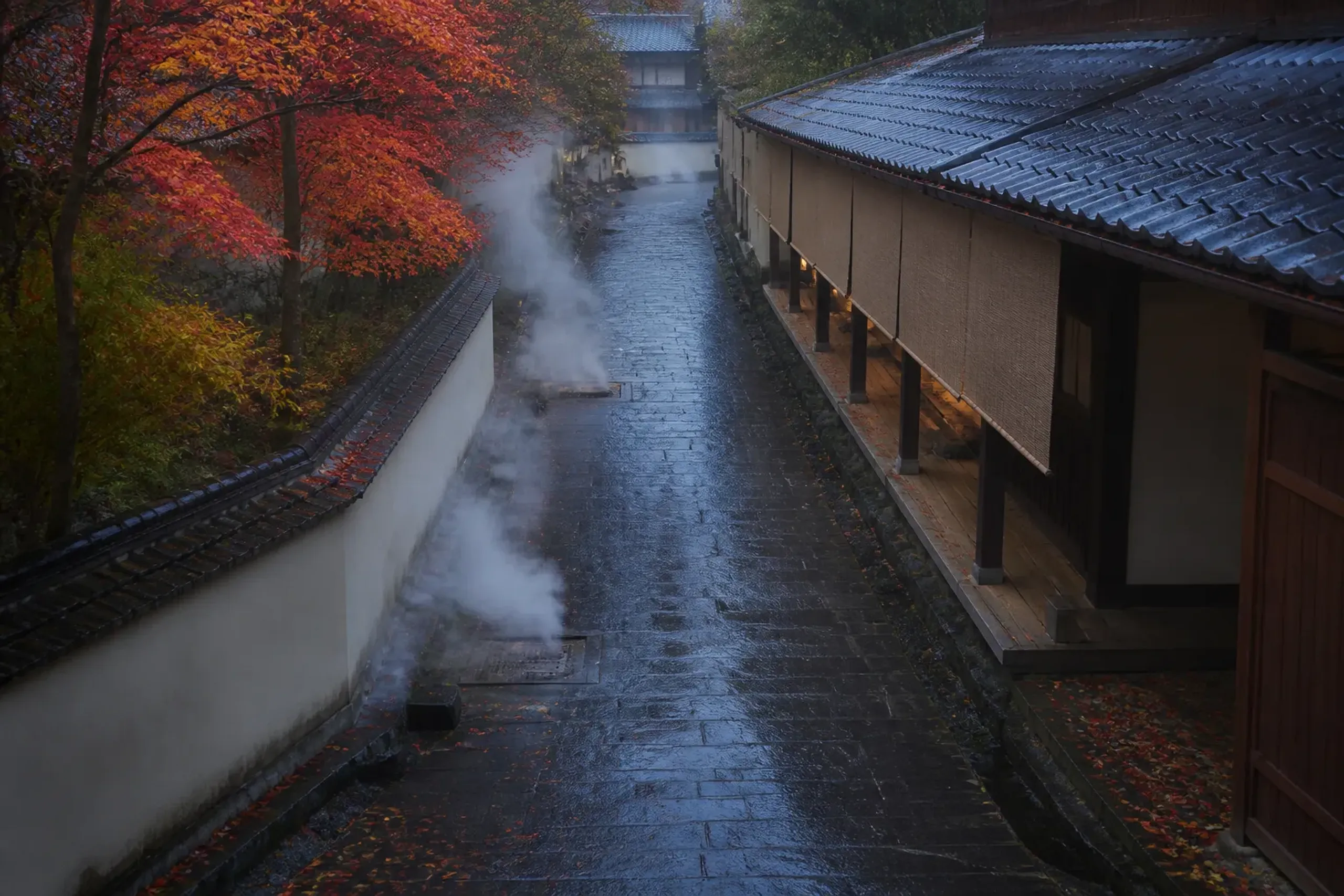 Early morning onsen-town walkway with steam and quiet covered paths, no people