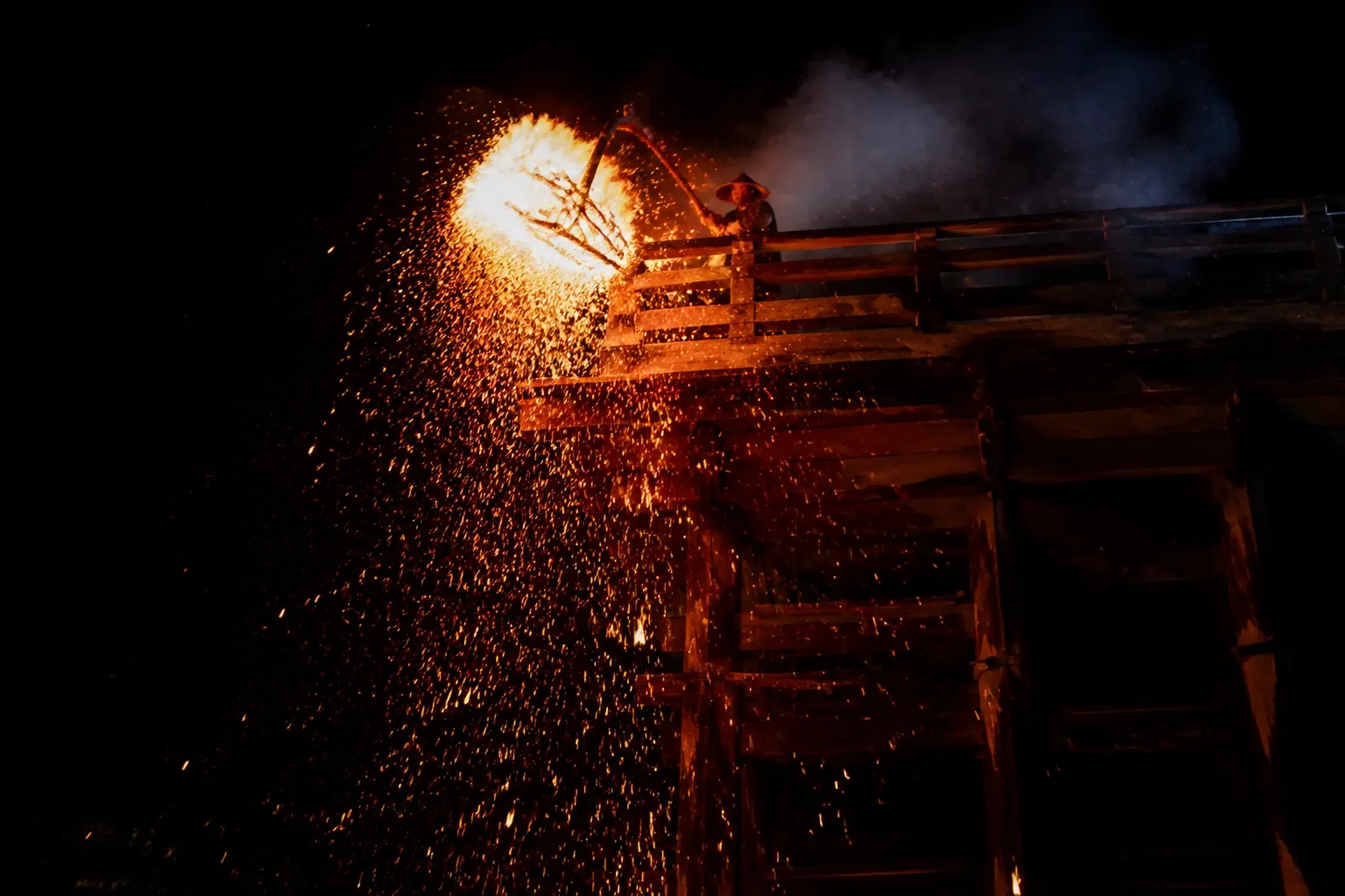 A dōji carries an Omizutori torch along the Nigatsu-dō balcony as sparks fall