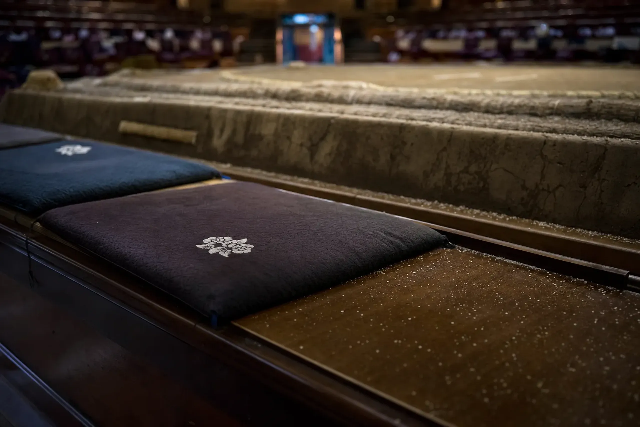 The tamari-seki sand cushions ringing the clay dohyo at the front of the Ryogoku Kokugikan, viewed from floor level