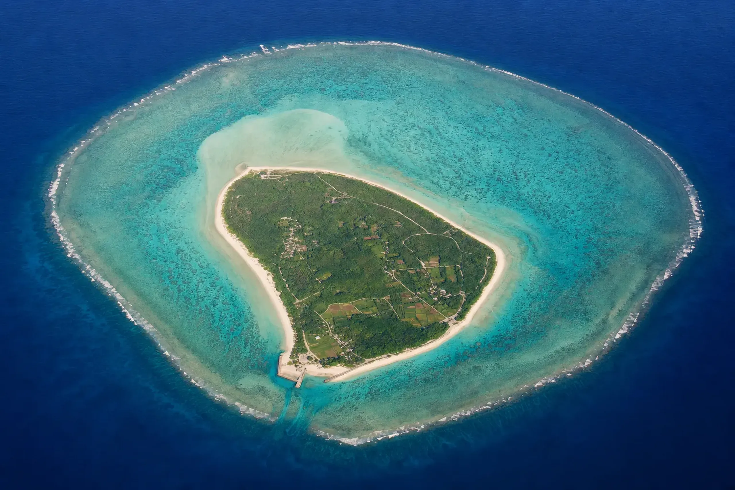 an aerial view of Yoron Island ringed by its coral reef and turquoise lagoon within Amami Gunto National Park