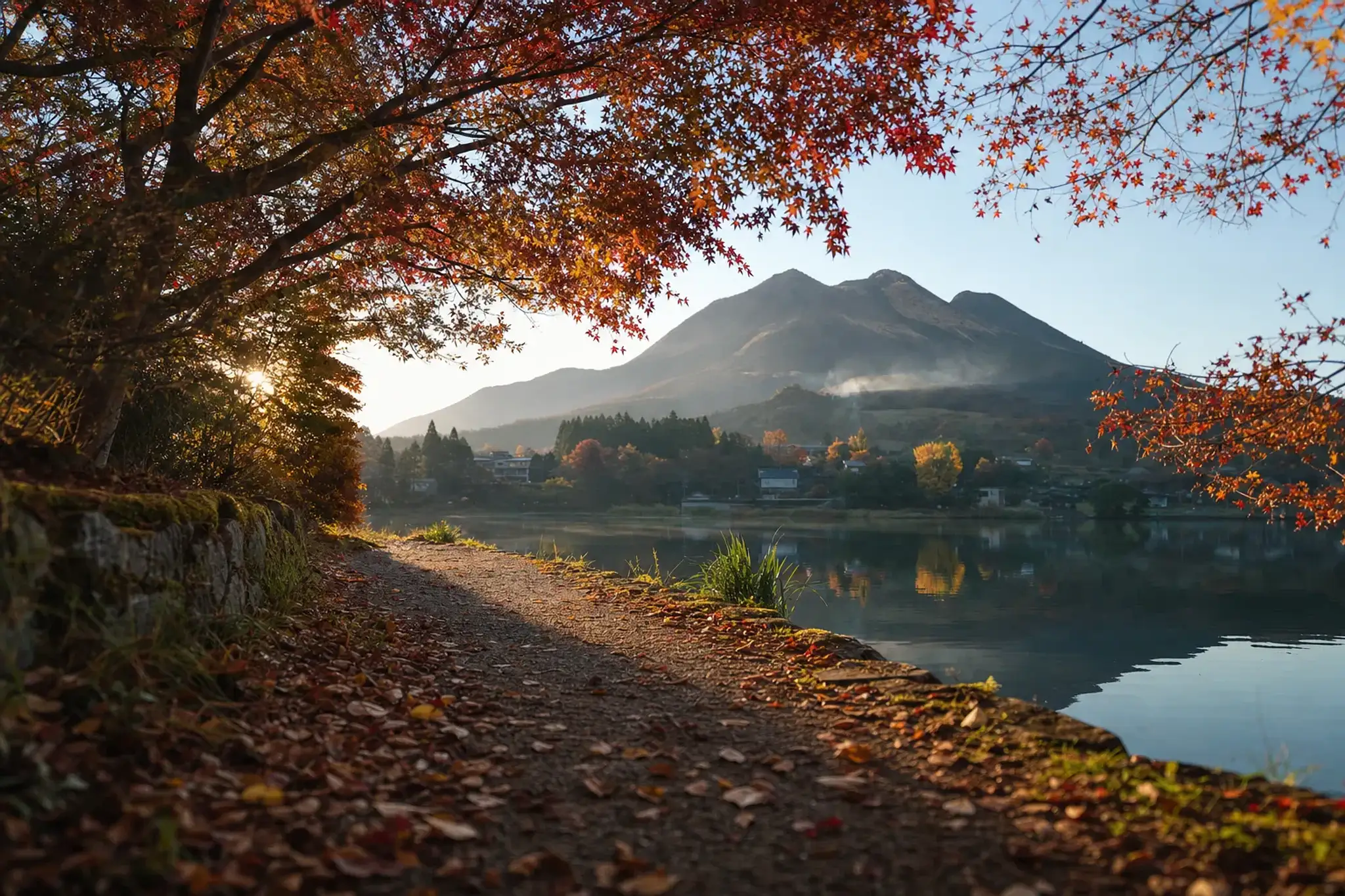 Autumn foliage in the Yufuin mountain basin at the base of Mount Yufu, red and gold leaves surrounding a quiet lakeside path