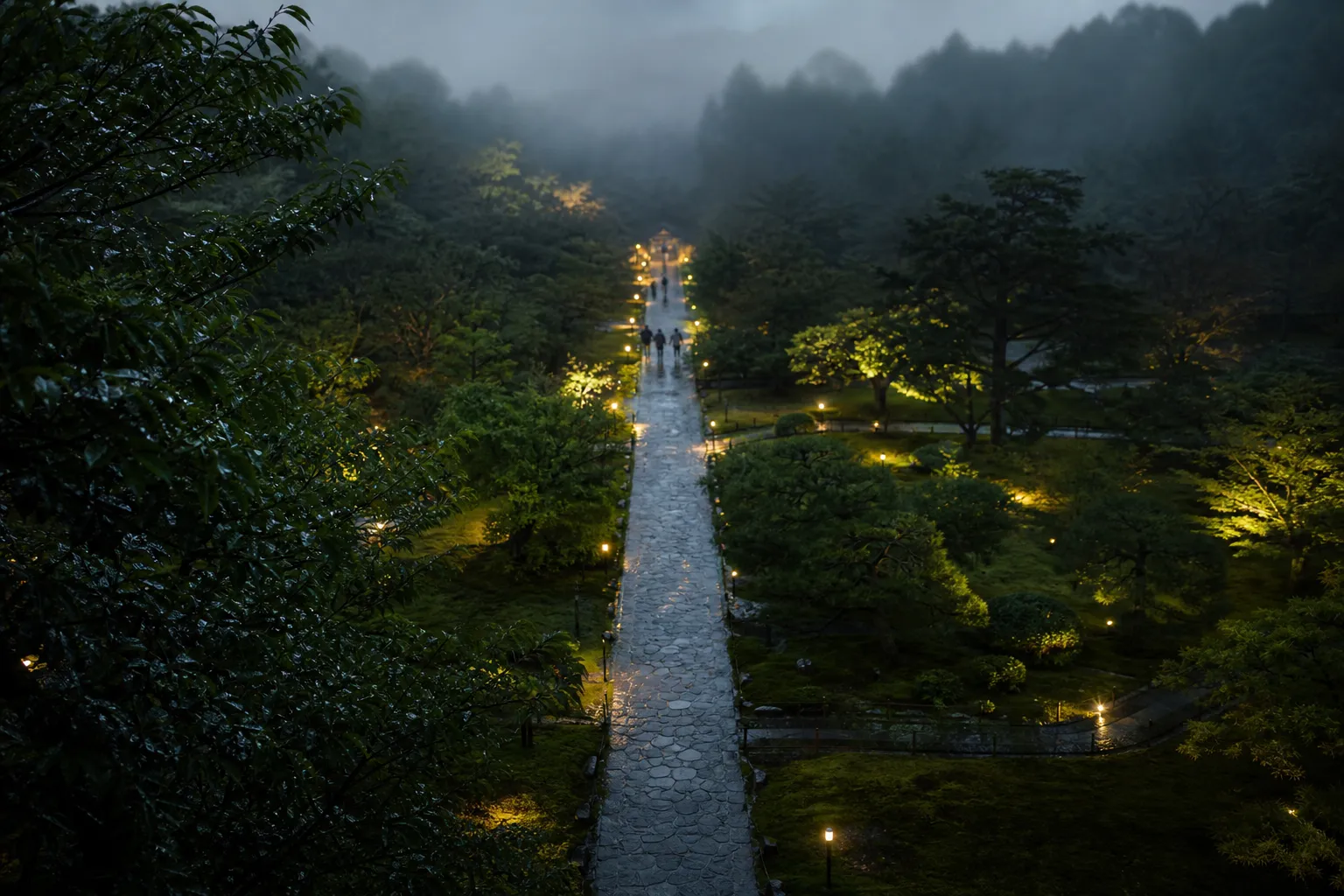 Illuminated path through trees at Kyoto Botanical Gardens at night