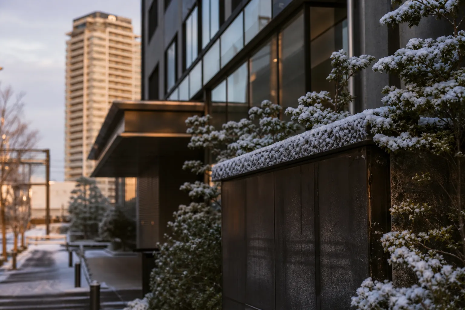 Contemporary luxury hotel exterior in Osaka at night with understated lighting