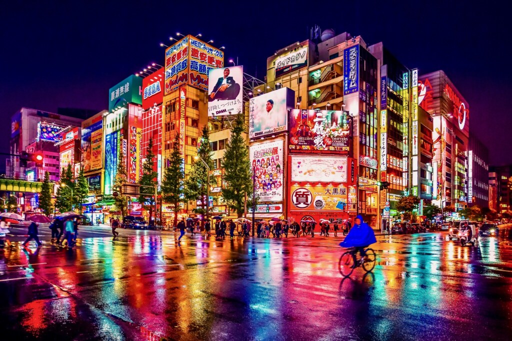 Tokyo, Japan - November 19, 2018: Neon lights and billboard advertisements on buildings at Akihabara at rainy night. Akihabara is a shopping district for video games, anime, manga, and computer goods.