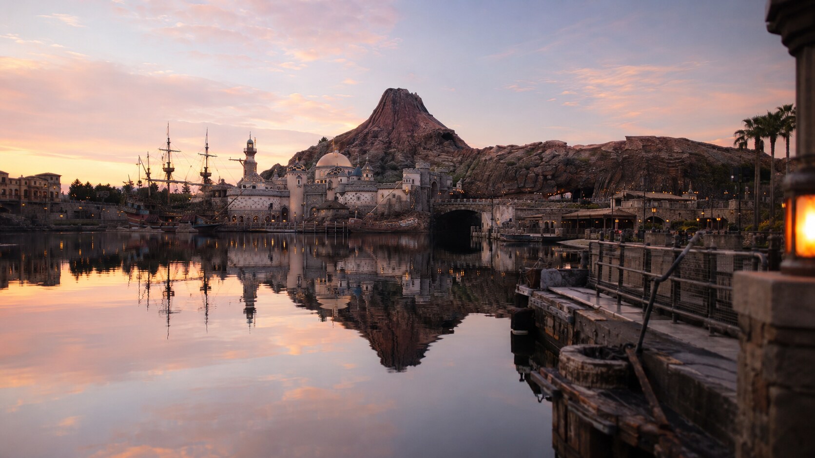 A serene sunrise view of Mount Prometheus and Mediterranean Harbor at Tokyo DisneySea, showcasing a calm and uncrowded park.