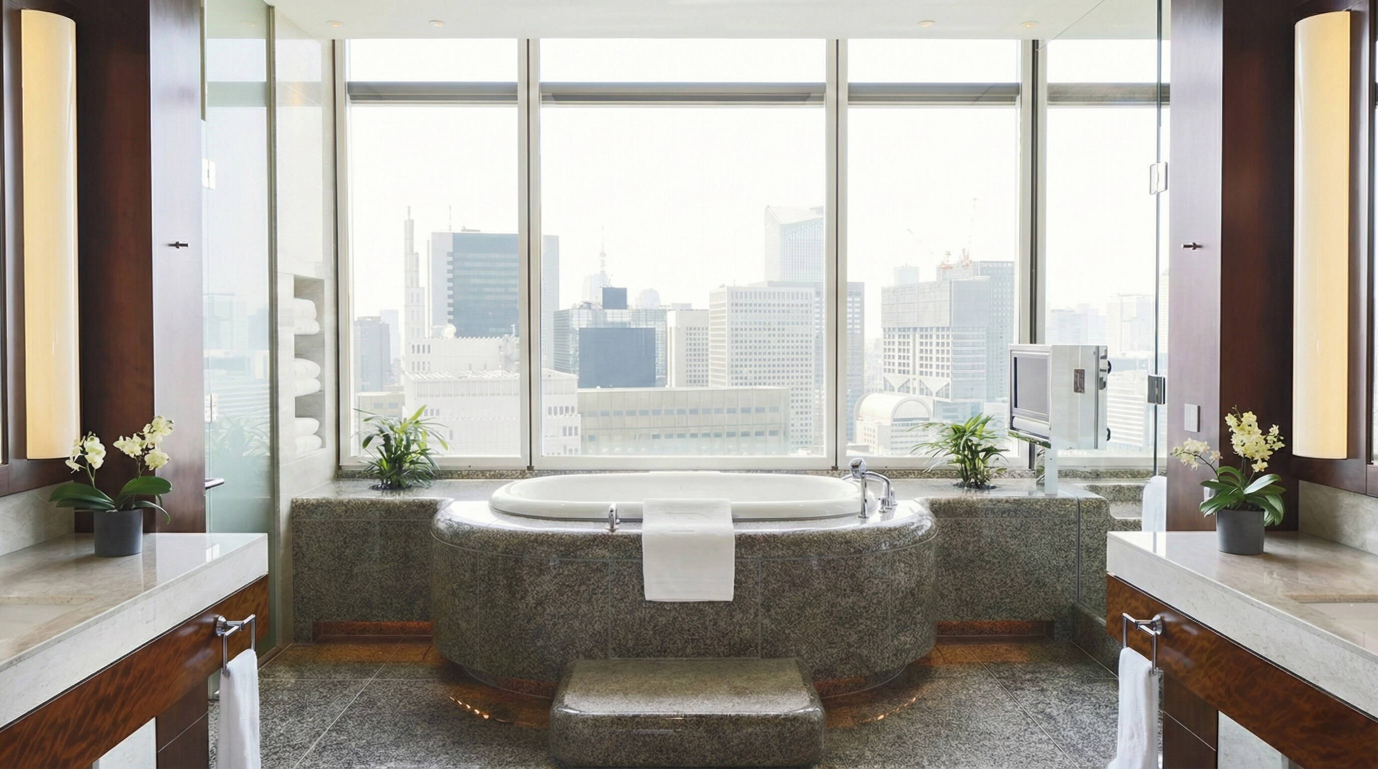 Luxurious marble bathroom in The Peninsula Suite with a city view soaking tub.