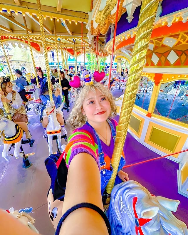 A professional and inviting portrait of @shell_dayo at Tokyo Disney Resort®. She is smiling warmly at the camera, dressed in a stylish outfit perfect for a day at the park.
