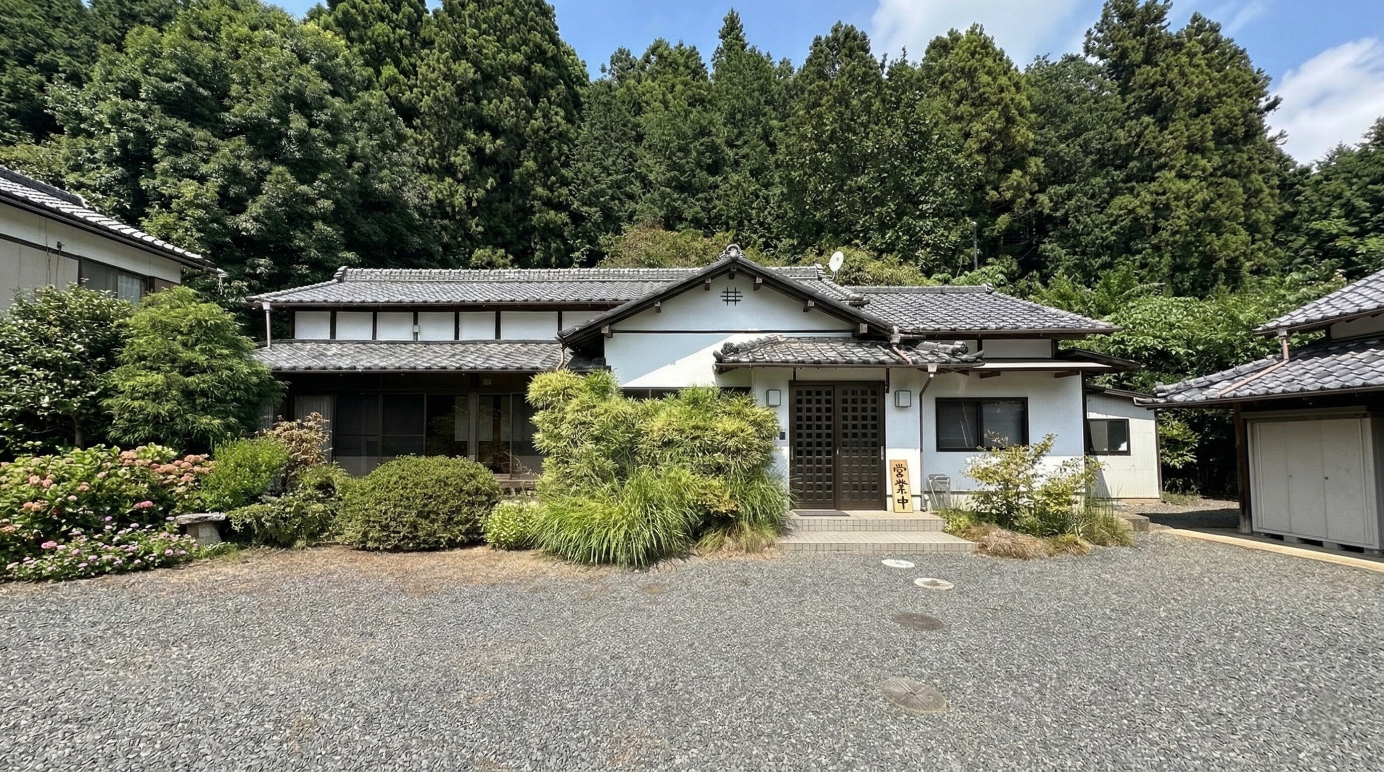 The exterior of Soba-dokoro Goshonoiri, a traditional Japanese kominka nestled in the lush mountains of Tochigi.