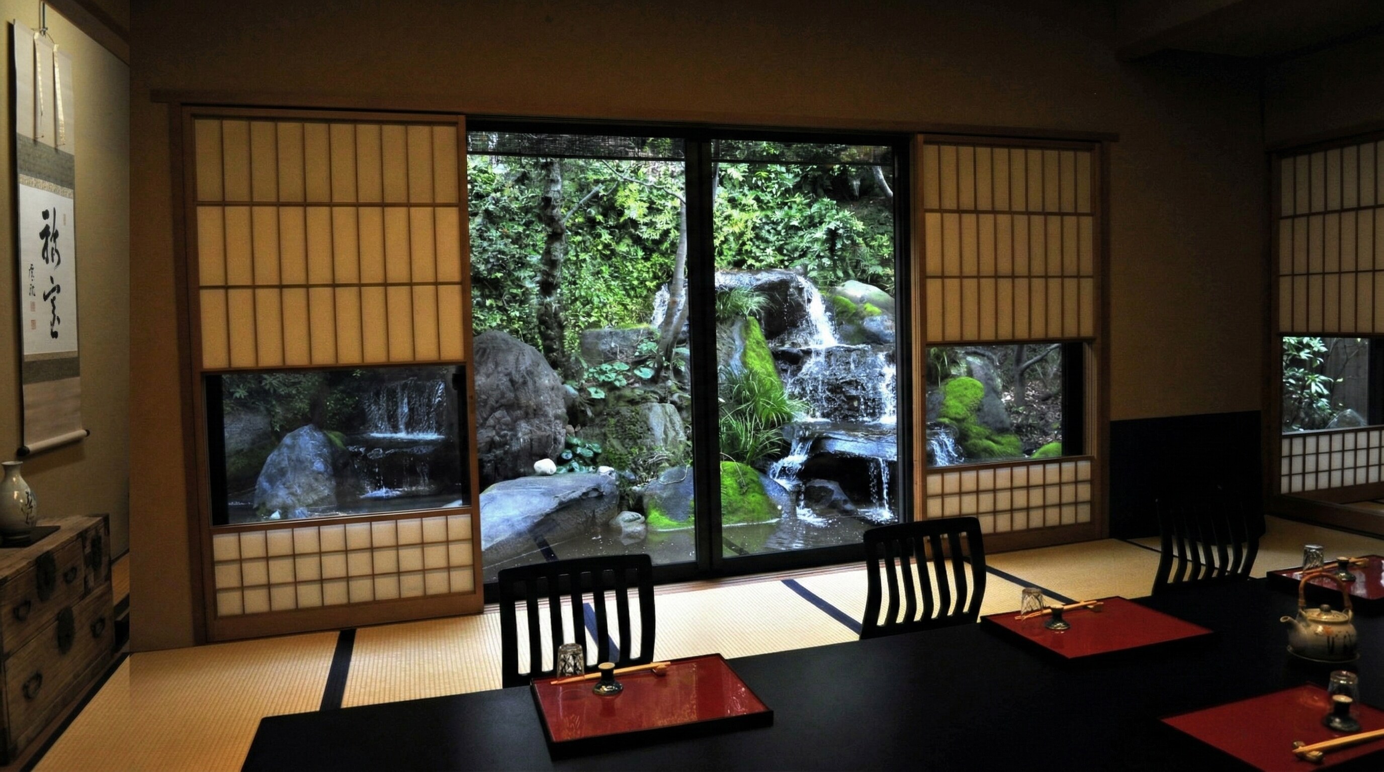 A luxurious, private tatami dining room with golden sliding doors and a view of a Japanese garden.
