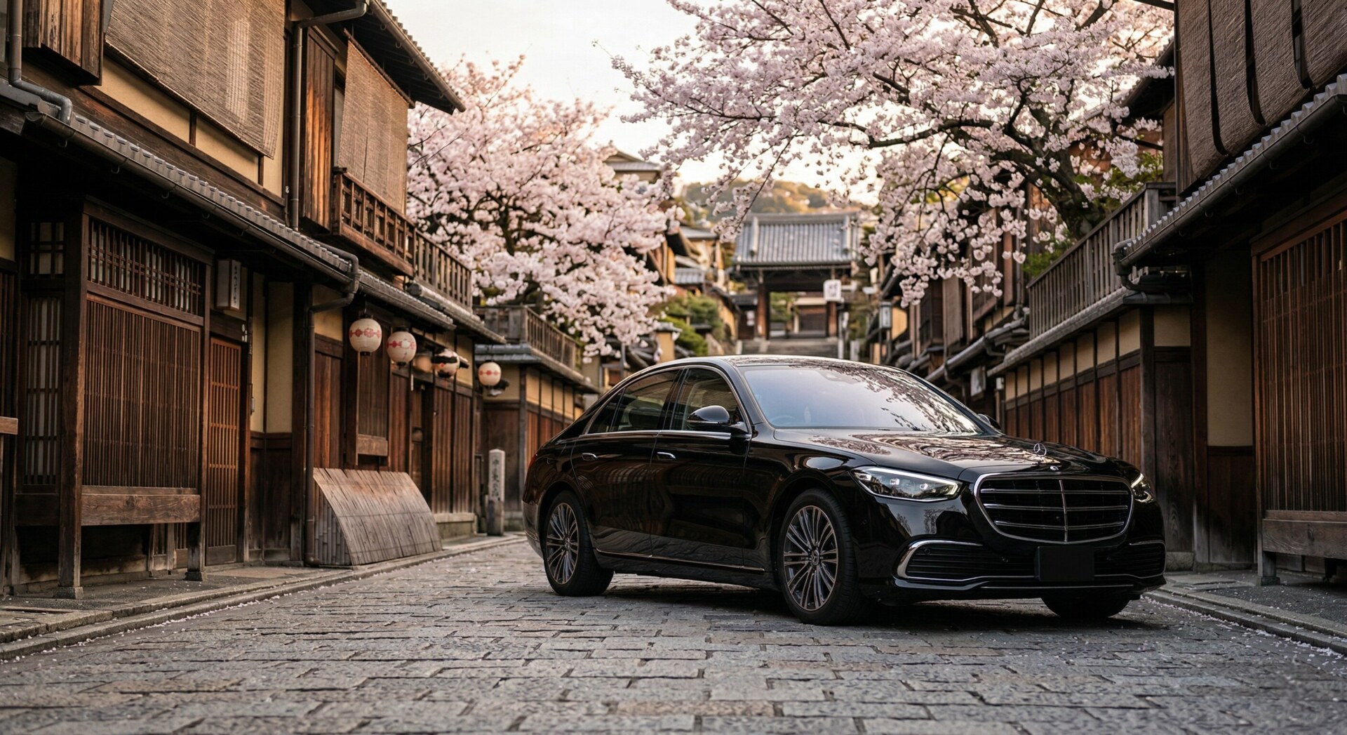 A sleek, black luxury sedan waiting patiently on a traditional cobblestone street in Kyoto.