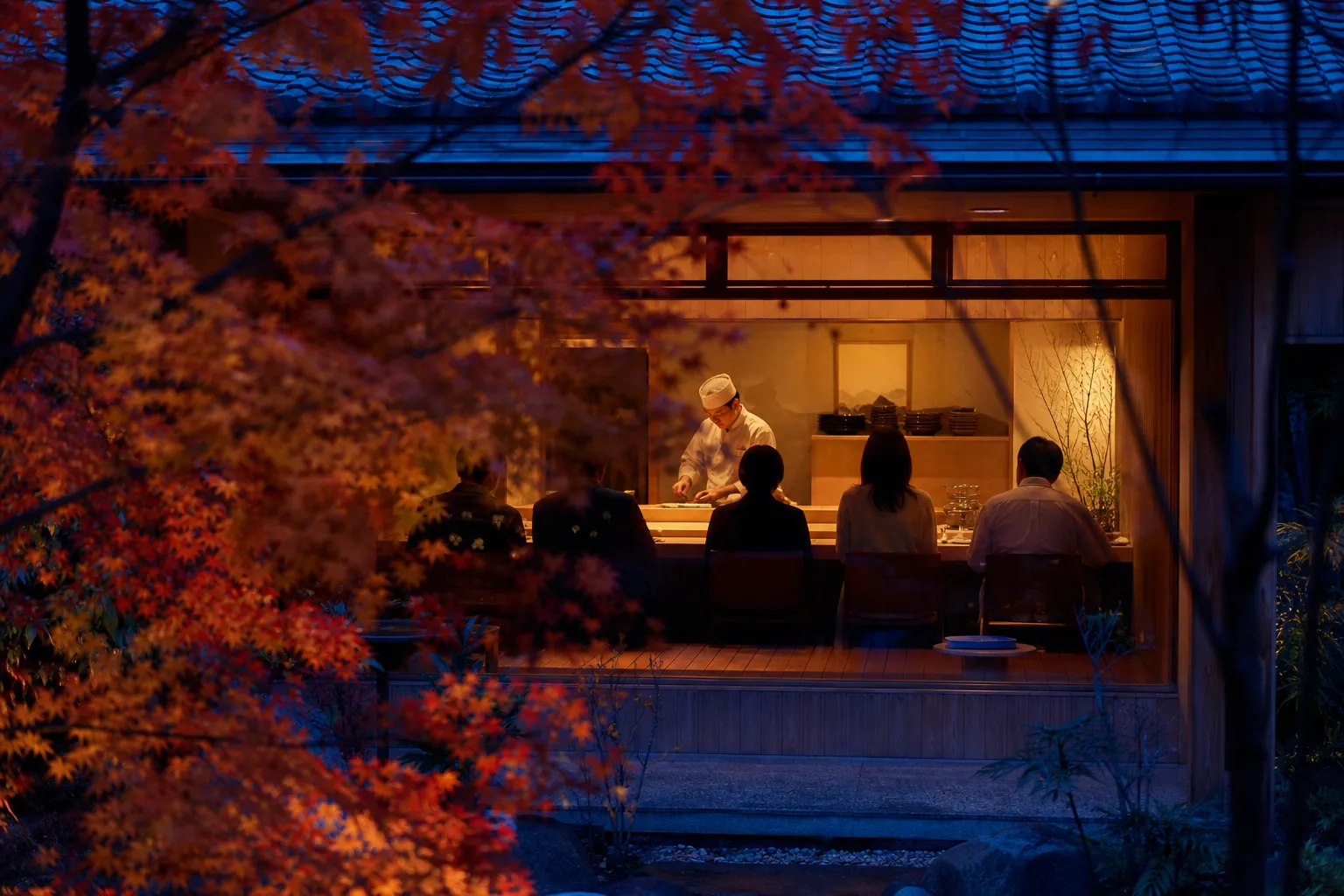 Chef preparing food at an intimate kappo counter in Osaka with warm wooden interior